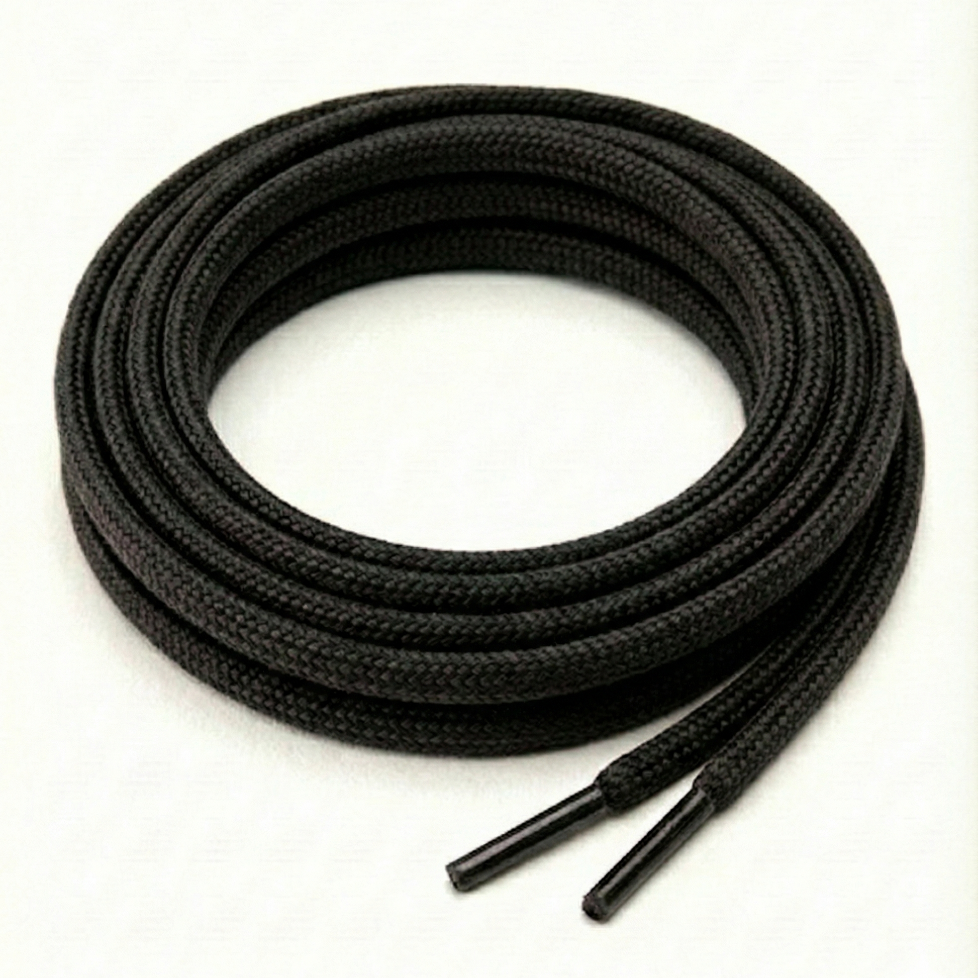 Coiled black shoelace on a white background